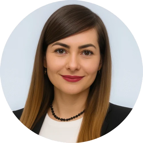 | Stream Telecom Professional headshot of a smiling woman with long brown hair, wearing a black blazer, white top, and a black beaded necklace.